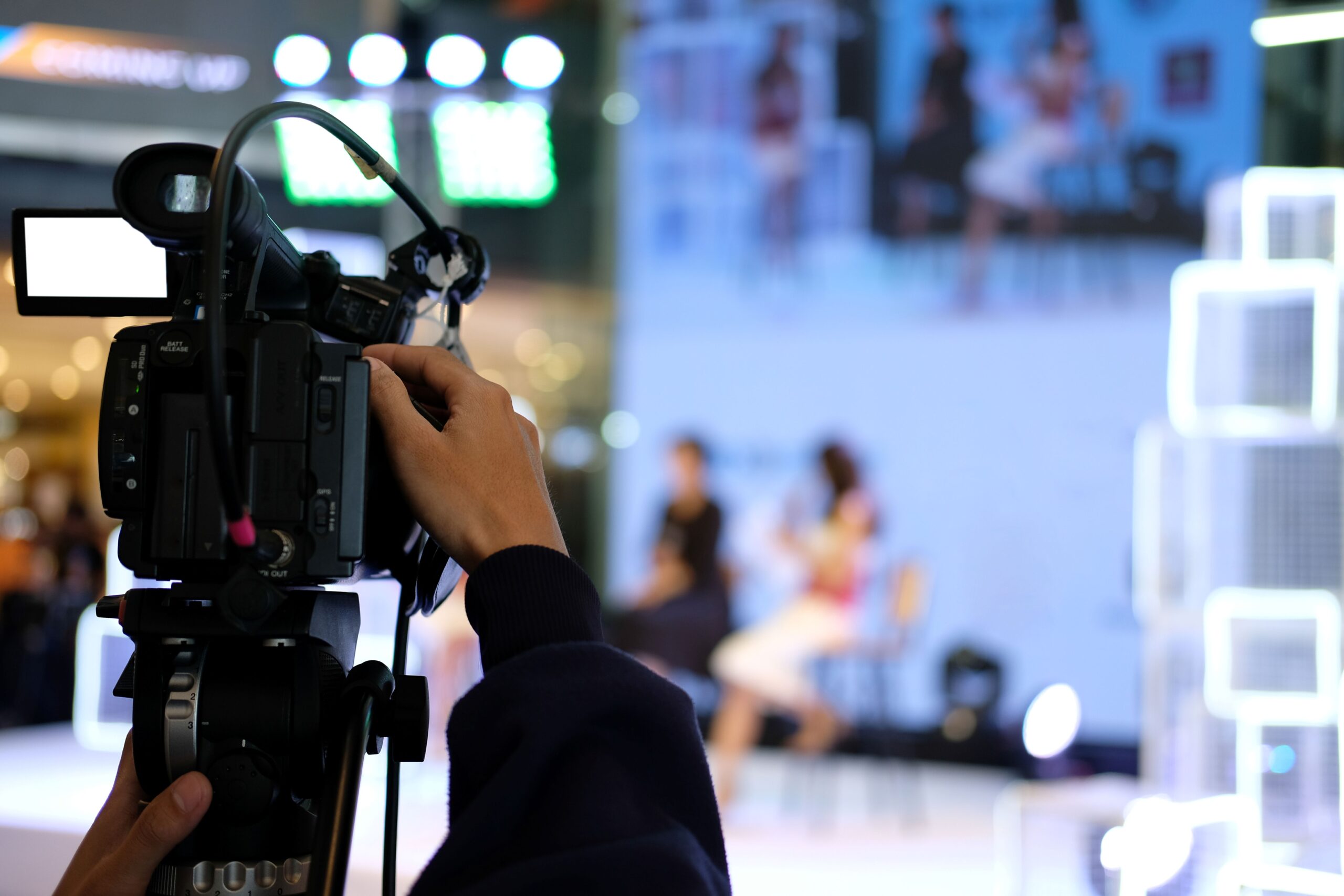 Hand mit Kamera filmt eine Live-Szene – Planung und Umsetzung einer Videoproduktion